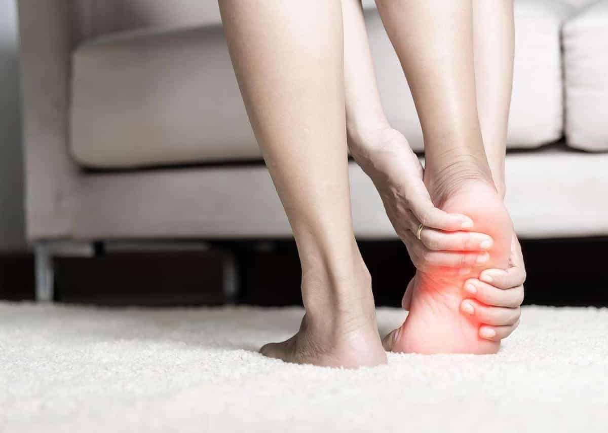 Woman holding her heel in pain from plantar fasciitis