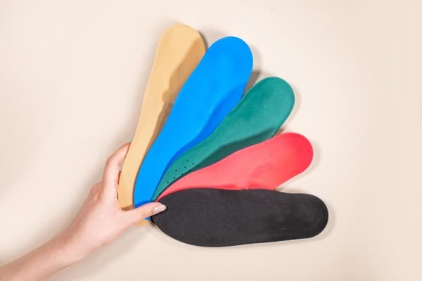 A variety of orthotic insoles in different colours