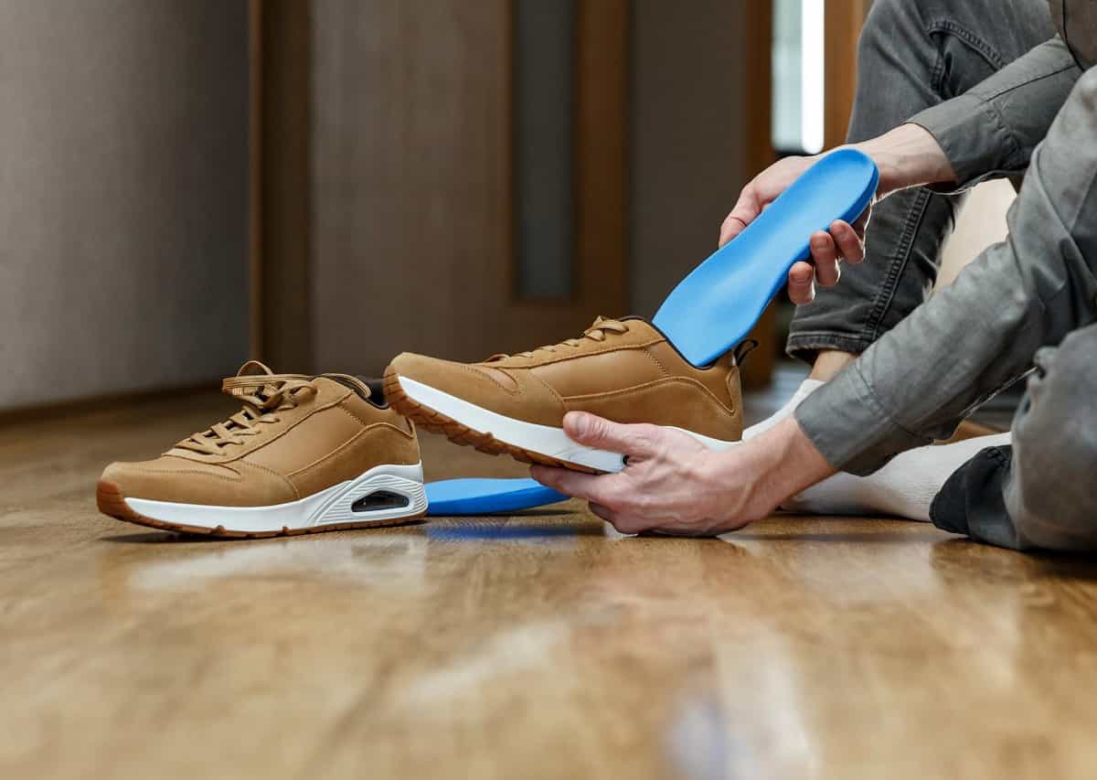 Man inspecting condition of orthotics insoles